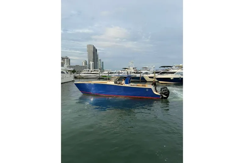 Slide: The Image of 2024 Custom Catamaran SET CAT in marina, blue hull, city skyline background. - 23