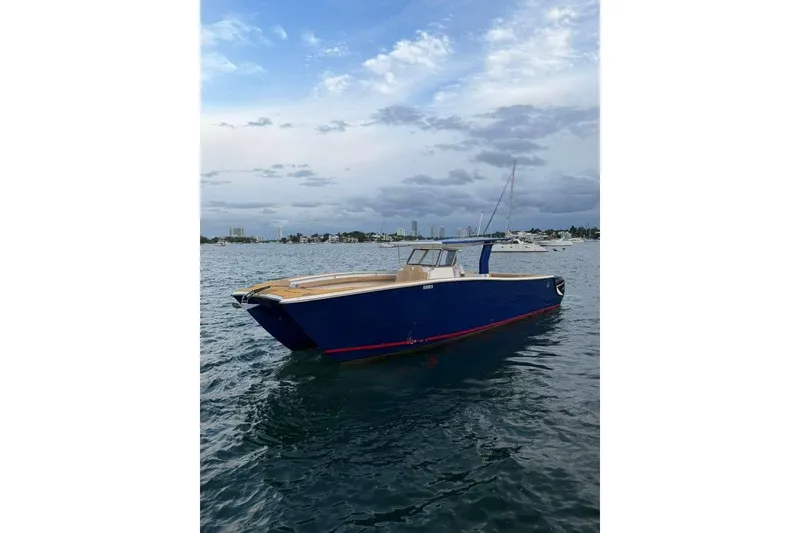 Slide: The Image of Custom 2024 Catamaran SET CAT on water, sleek design, blue hull, city skyline background. - 25