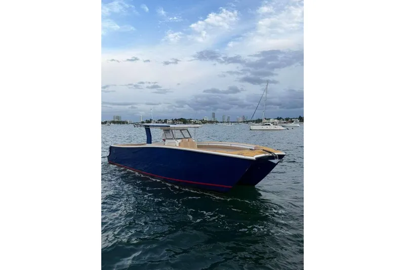 Slide: The Image of 2024 Custom Catamaran SET CAT on water, blue hull, clear sky, distant boats. - 36