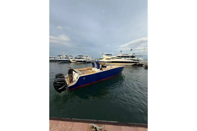 Slide: The Image of 2024 Custom Catamaran SET CAT docked, featuring sleek blue design and powerful Mercury engines. - 42