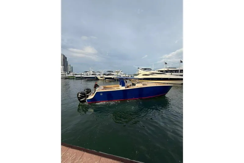 Slide: The Image of 2024 Custom Catamaran SET CAT in marina, blue hull, docked near luxury yachts. - 43