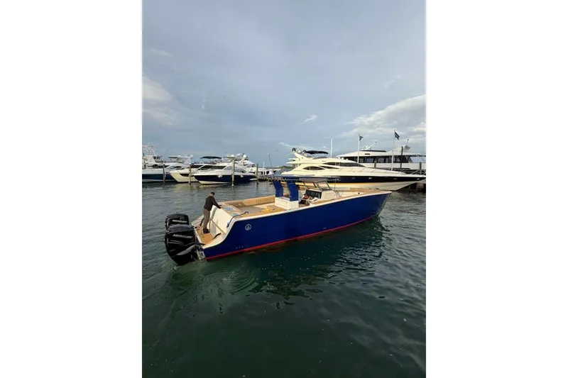 Slide: The Image of 2024 Custom Catamaran SET CAT in marina, featuring sleek blue design and dual Mercury engines. - 46