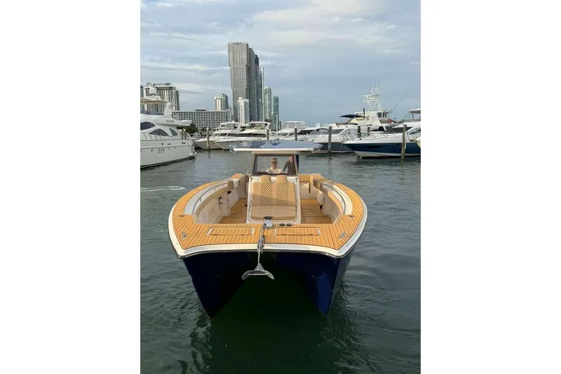 Slide: The Image of 2024 Custom Catamaran SET CAT docked in marina, city skyline in background. - 51