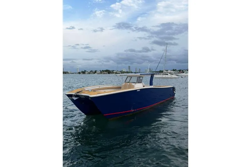 Slide: The Image of 2024 Custom Catamaran SET CAT on water, sleek blue design, cloudy sky backdrop. - 64