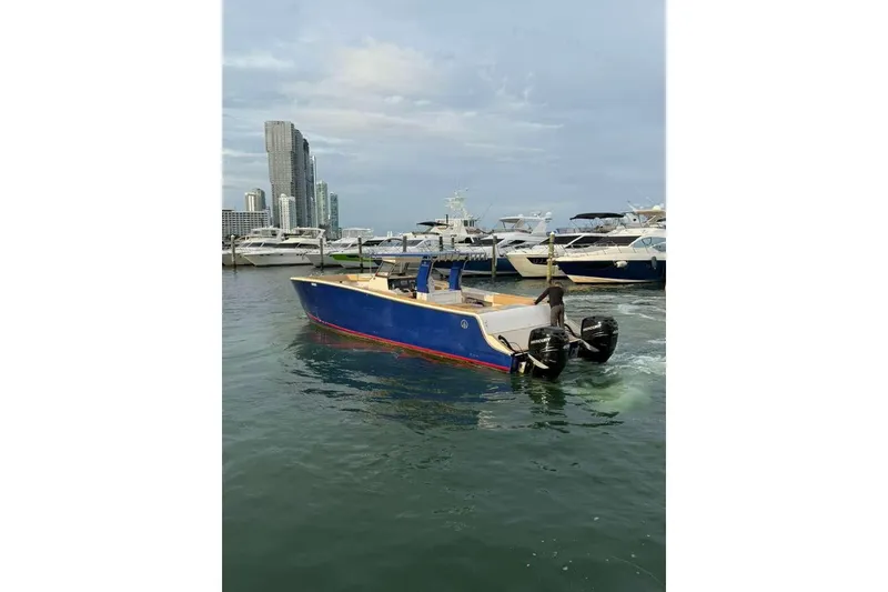 Slide: The Image of 2024 Custom Catamaran SET CAT in marina, blue hull, twin outboard motors. - 78