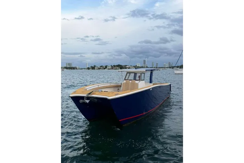 Slide: The Image of 2024 Custom Catamaran SET CAT on water, sleek design, blue hull, city skyline background. - 85