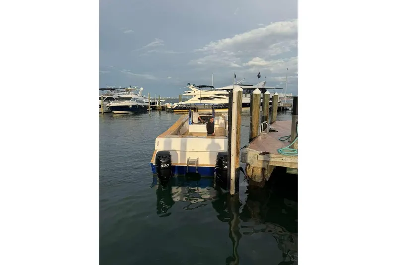 Slide: The Image of 2024 Custom Catamaran SET CAT docked at marina with outboard motor. - 87