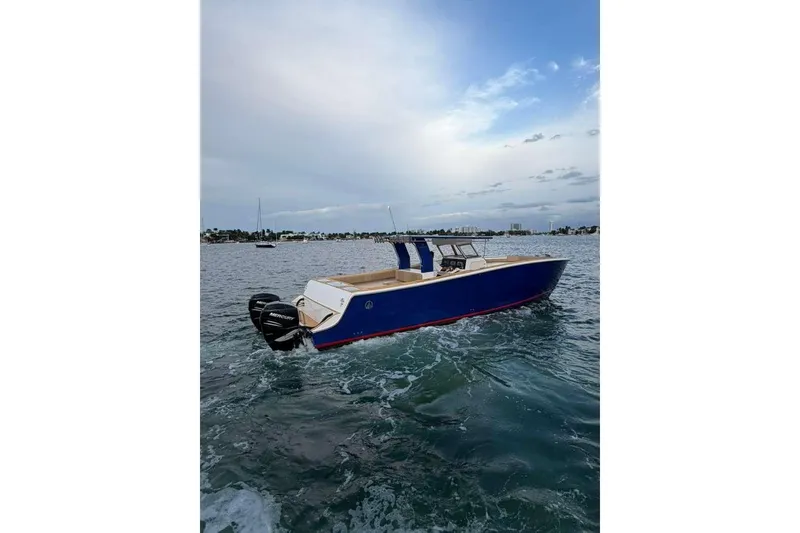 Slide: The Image of 2024 Custom Catamaran SET CAT on open water, featuring sleek blue design and powerful outboard motor. - 88
