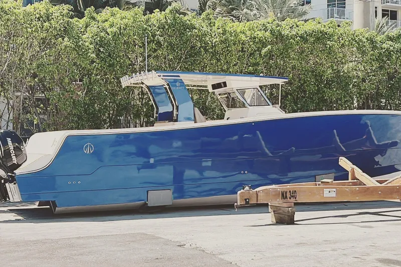 Slide: The Image of 2024 Custom Catamaran SET CAT in vibrant blue, docked outdoors with lush greenery. - 92