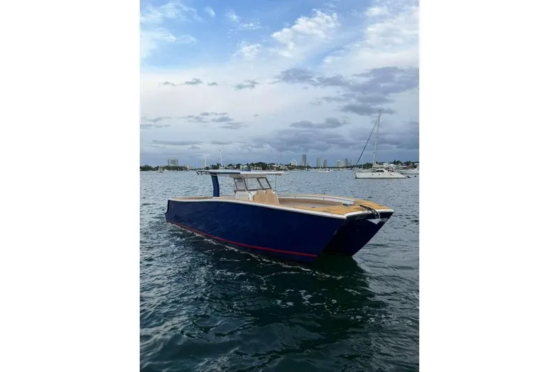 Slide: The Image of 2024 Custom Catamaran SET CAT on calm waters, with city skyline in the background. - 94