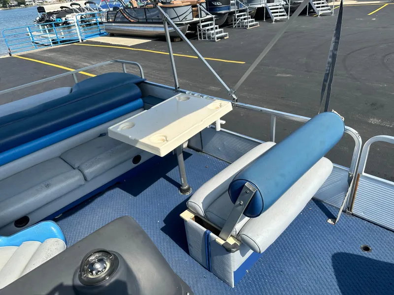 Slide: The Image of 1989 AquaPatio 24 pontoon boat interior with blue seating and a foldable table. - 10