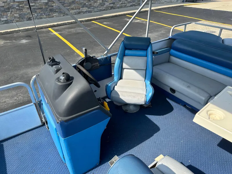 Slide: The Image of 1989 AquaPatio 24 boat interior with blue seating and steering console. - 11