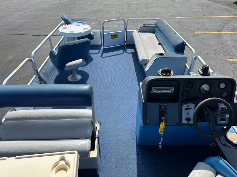 Slide: The Image of 1989 AquaPatio 24 pontoon boat interior with blue seating and steering console. - 13