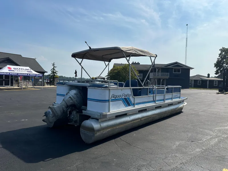 Slide: The Image of 1989 AquaPatio 24 pontoon boat parked outdoors on a sunny day. - 5