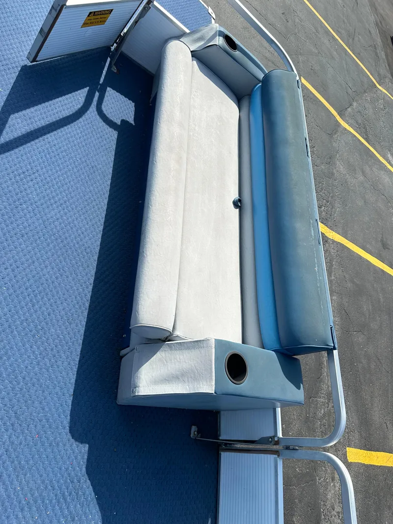 Slide: The Image of 1989 AquaPatio 24 boat seat with blue and white upholstery, docked on a sunny day. - 7