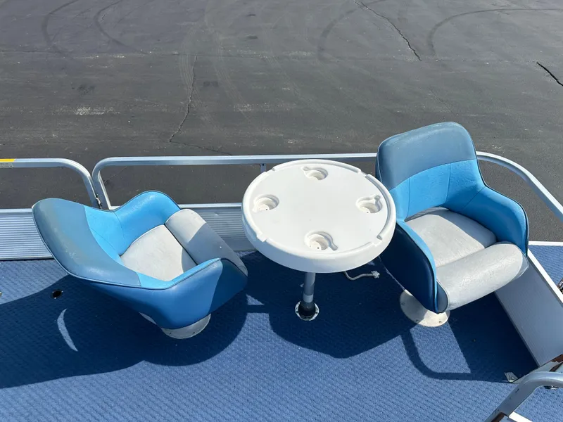 Slide: The Image of Two blue seats and a round table on a 1989 AquaPatio 24 boat deck. - 8