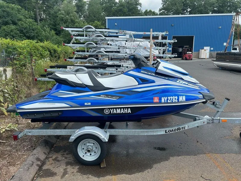 Slide: The Image of 2017 Yamaha WaveRunner GP1800 on trailer, parked outdoors near blue building. - 2