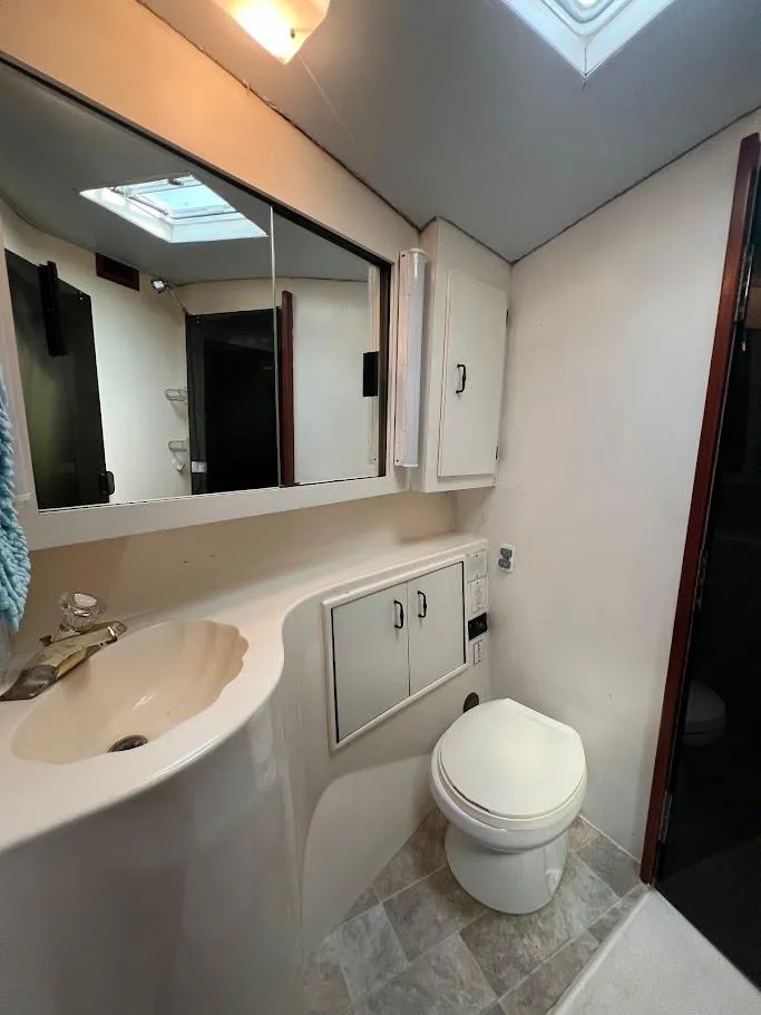 Slide: The Image of 1987 Ocean Yachts Super Sport bathroom with sink, toilet, and mirrored cabinet. - 10