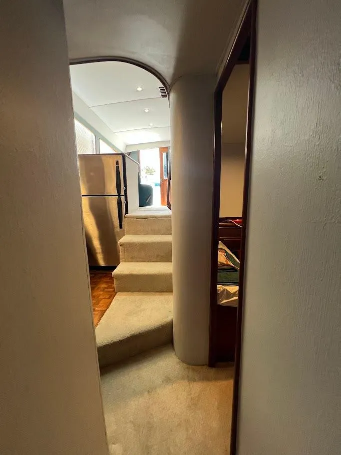Slide: The Image of Interior view of 1987 Ocean Yachts Super Sport, featuring a narrow hallway and staircase. - 11