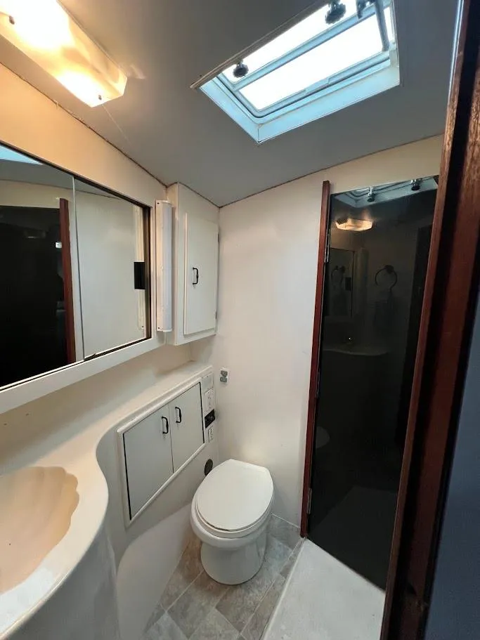 Slide: The Image of Bathroom interior of 1987 Ocean Yachts Super Sport with skylight and modern fixtures. - 14