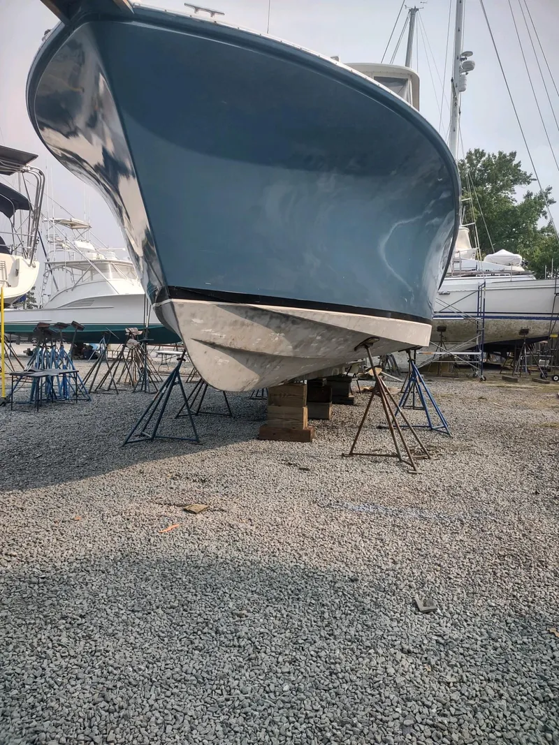 Slide: The Image of 1987 Ocean Yachts 44 Super Sport boat on stands in a gravel yard. - 17