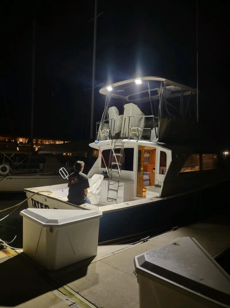 Slide: The Image of 1987 Ocean Yachts 44 Super Sport docked at night, illuminated by deck lights. - 18