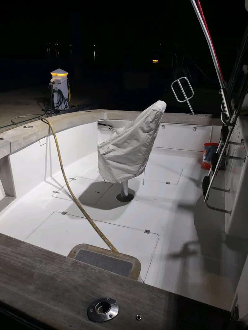 Slide: The Image of 1987 Ocean Yachts 44 Super Sport boat deck at night, featuring covered seating. - 19