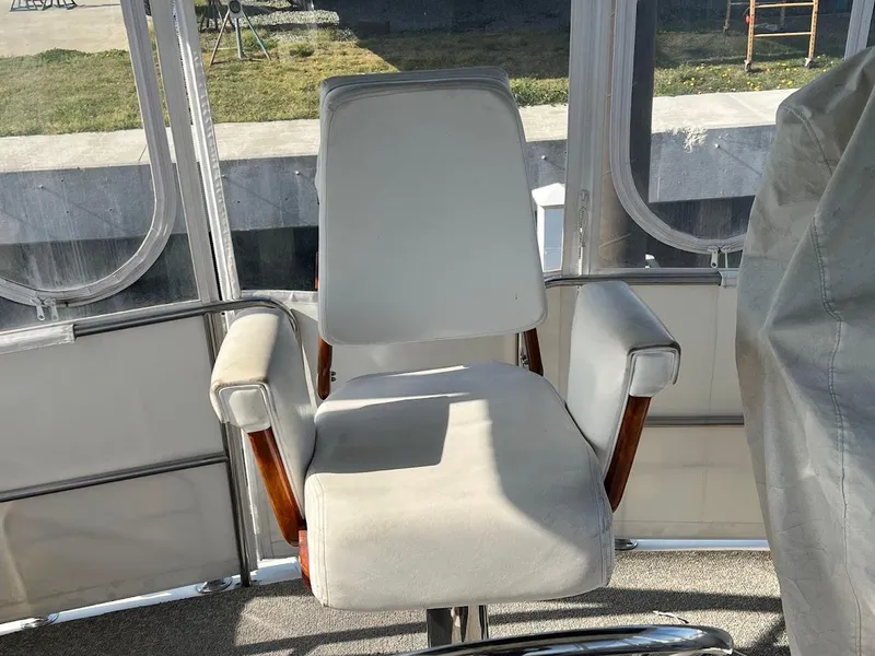 Slide: The Image of Captain's chair on 1987 Ocean Yachts Super Sport boat, featuring white upholstery and wooden armrests. - 22