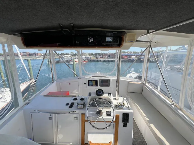 Slide: The Image of 1987 Ocean Yachts Super Sport cockpit with steering wheel, navigation equipment, and marina view. - 23