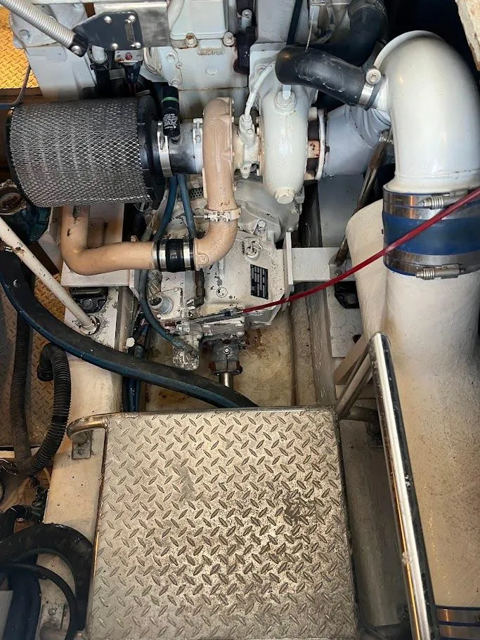 Slide: The Image of Engine room of a 1987 Ocean Yachts Super Sport, showcasing mechanical components and piping. - 25