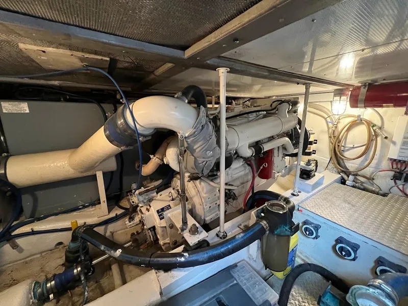 Slide: The Image of Engine room of a 1987 Ocean Yachts Super Sport, showcasing mechanical components and piping. - 26