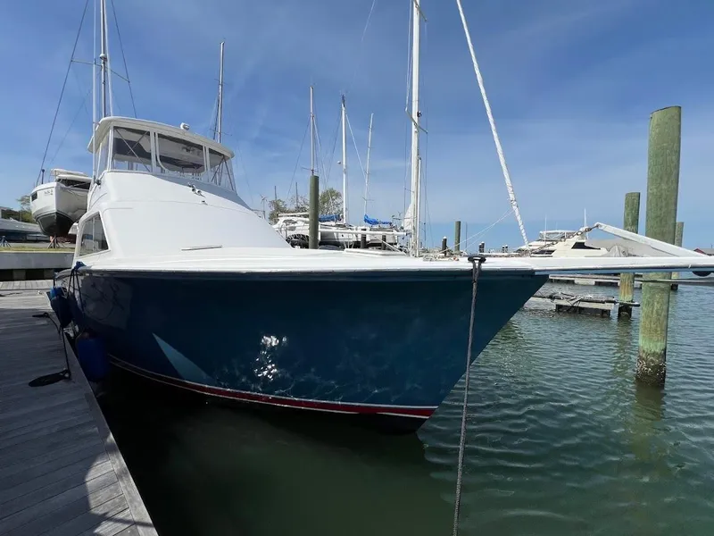 Slide: The Image of 1987 Ocean Yachts Super Sport docked at a marina under clear blue skies. - 32