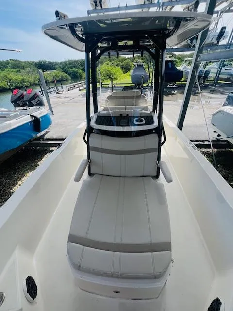 Slide: The Image of 2023 Boston Whaler 250 Dauntless boat interior with seating and console, docked outdoors. - 12