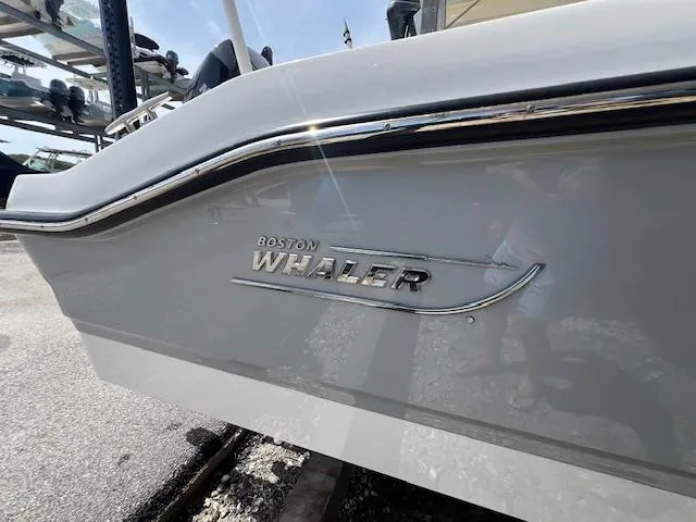 Slide: The Image of 2023 Boston Whaler 250 Dauntless boat side view with logo and chrome detailing. - 23