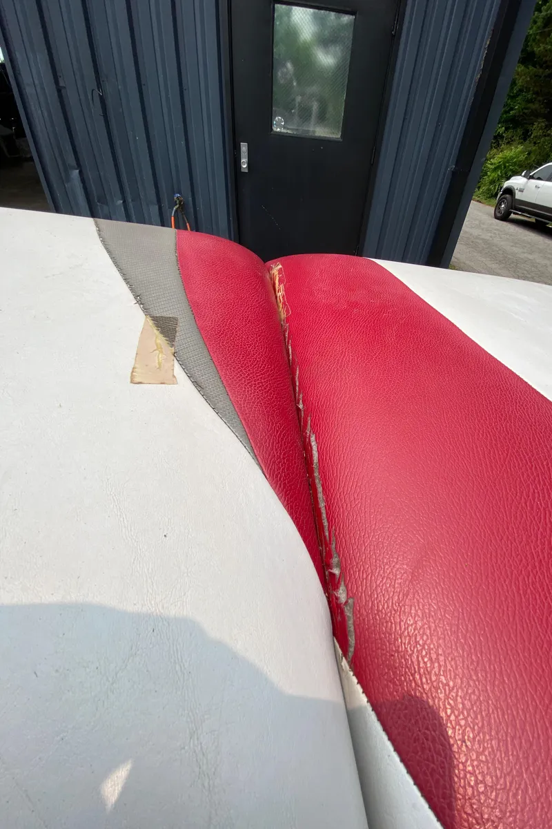 Slide: The Image of 2011 Moomba Mobius LSV boat seat with red and white upholstery, showing wear and tear. - 11