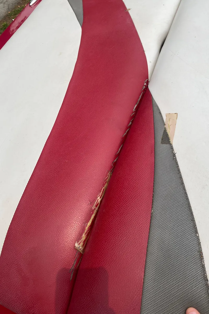 Slide: The Image of Torn upholstery on 2011 Moomba Mobius LSV boat seat, red and gray fabric. - 15