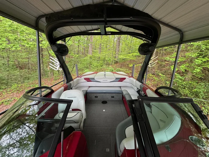 Slide: The Image of 2011 Moomba Mobius LSV boat interior with red and white seating under a canopy. - 3