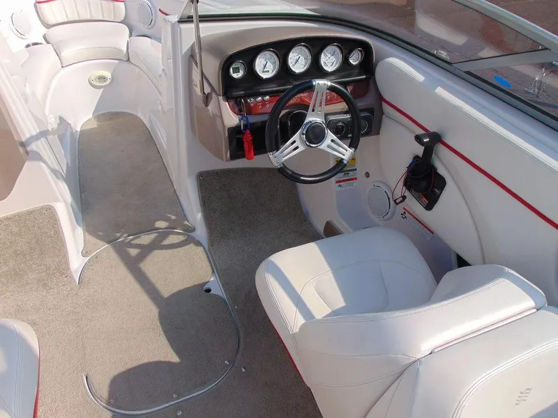 Slide: The Image of 2009 Four Winns H210 boat interior with steering wheel and dashboard gauges. - 10