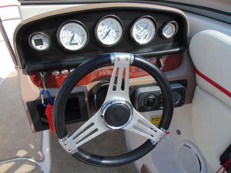 Slide: The Image of 2009 Four Winns H210 boat dashboard with steering wheel and gauges. - 11