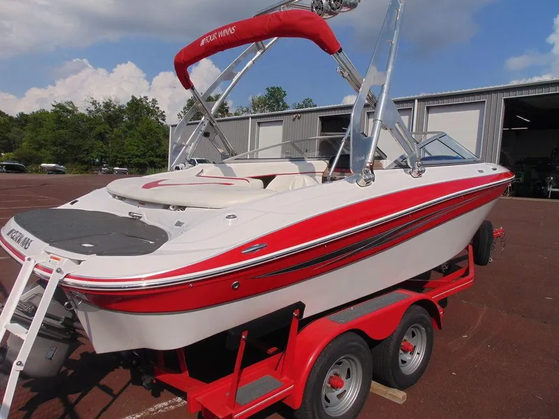 Slide: The Image of 2009 Four Winns H210 boat on red trailer, parked outdoors. - 5