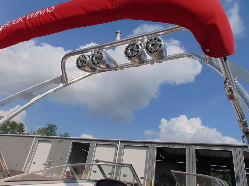 Slide: The Image of 2009 Four Winns H210 boat with red canopy and mounted speakers. - 6