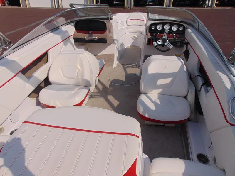 Slide: The Image of 2009 Four Winns H210 boat interior with white and red seating, sleek dashboard, and spacious layout. - 7