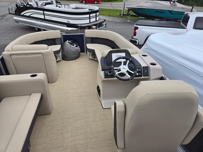 Slide: The Image of 2025 Harris Cruiser 210 FC pontoon boat interior with beige seating and steering console. - 6