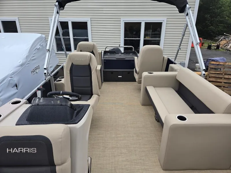 Slide: The Image of 2025 Harris Cruiser 210 FC pontoon boat interior with beige seating and steering console. - 8