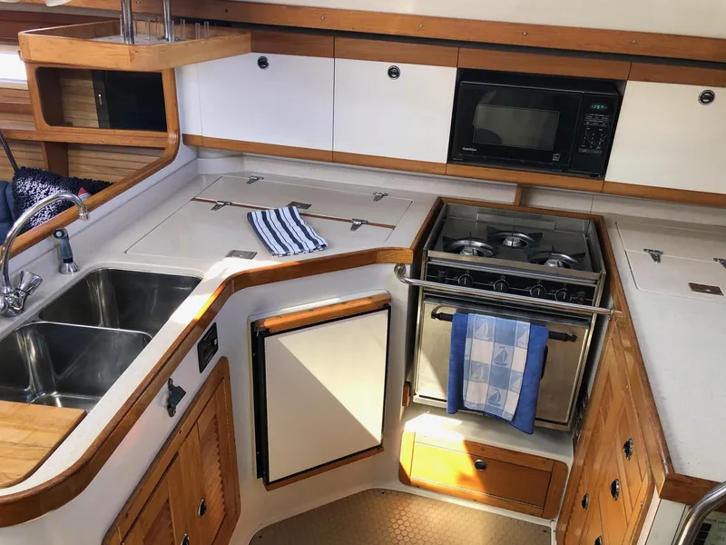 Slide: The Image of 1997 Catalina 400 yacht kitchen with stove, sink, and microwave. - 4