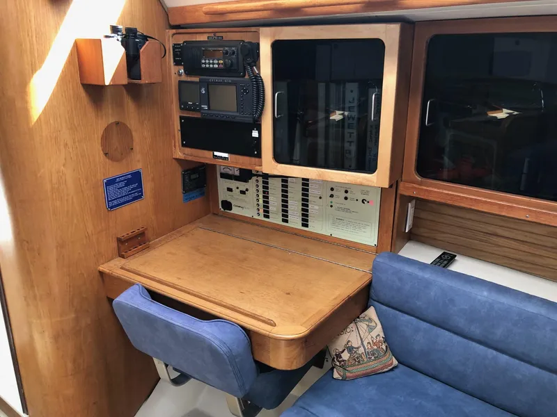Slide: The Image of Navigation station in 1997 Catalina 400 sailboat with wooden desk and blue seating. - 5