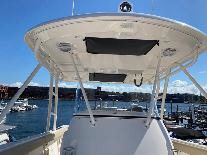 Slide: The Image of 2016 Pursuit S 280 Sport boat with T-top, docked at marina under clear blue sky. - 11