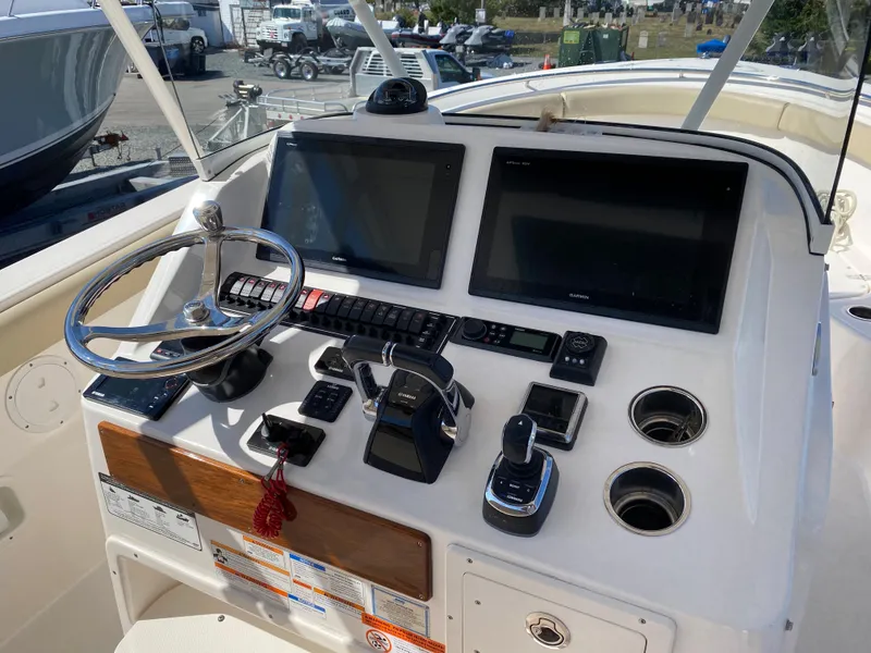 Slide: The Image of 2016 Pursuit S 280 Sport boat dashboard with dual screens and controls. - 13