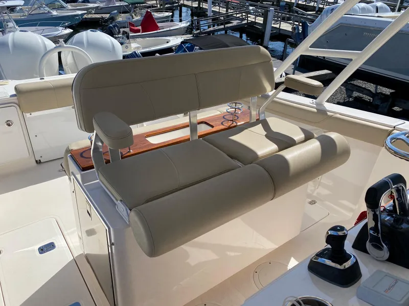 Slide: The Image of 2016 Pursuit S 280 Sport boat with beige seating at a marina. - 17