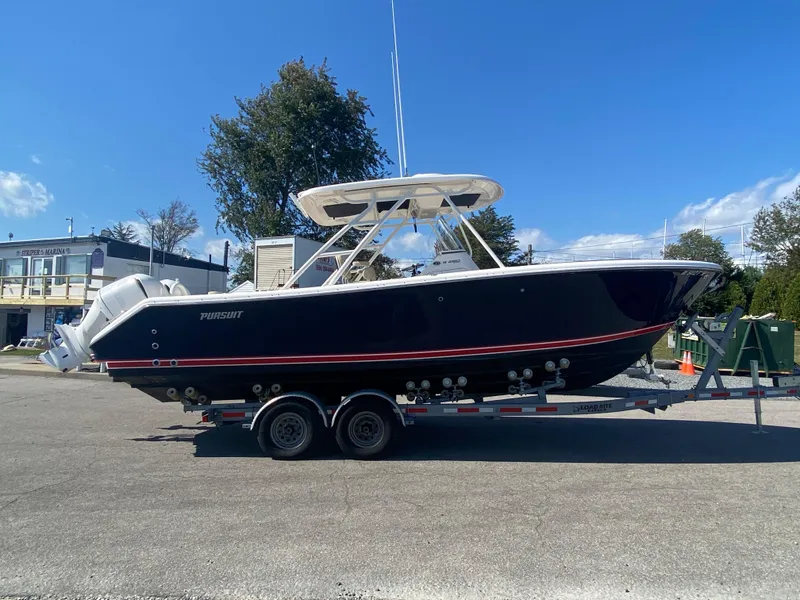 Slide: The Image of 2016 Pursuit S 280 Sport boat on trailer, parked outdoors under clear blue sky. - 2